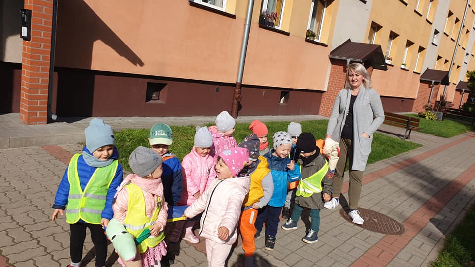 Zdjęcie przedstawia najmłodsze smyki podczas jesiennego spaceru w pobliżu przedszkola.