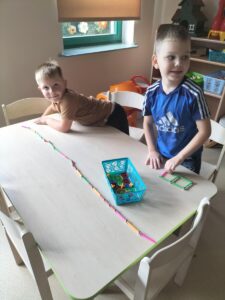 Zdjęcie przedstawia dwóch chłopców tworzących budowle z klocków magnetycznych.
