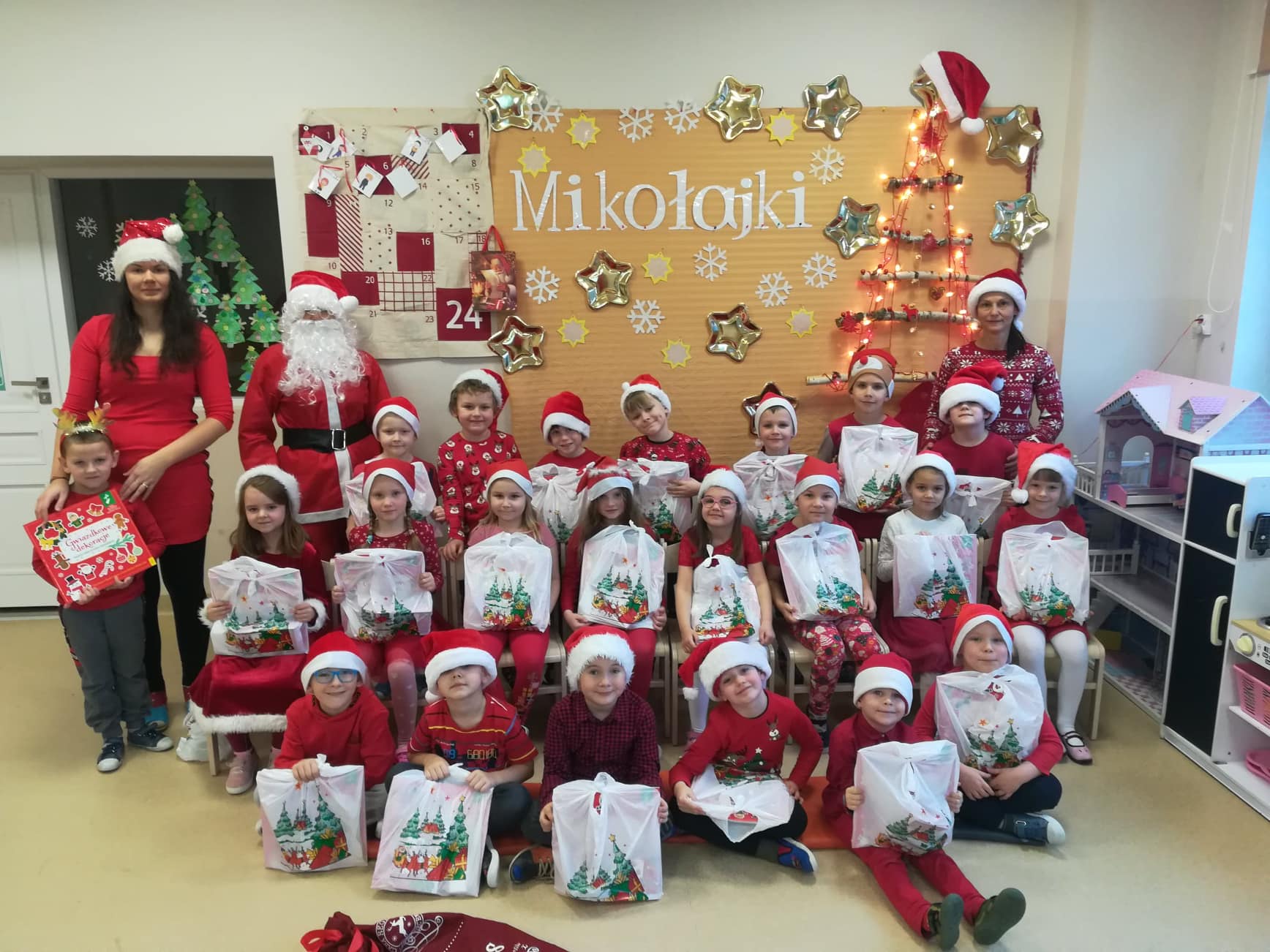 Grupa Tygryski pozuje do zdjęcia z Mikołajem, Panią Mikołajowa i Elfem.