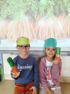 Na zdjęciu dzieci w opaskach marchewek prezentują swoje "marchewki"wykonane z rolek po papierze toaletowym.