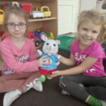 Zdjęcie ukazuje dwie dziewczynki trzymające pacynkę o imieniu Dusty. jest no nasz rezolutny królik, który pomaga Nam się oswajać z językiem angielskim.
