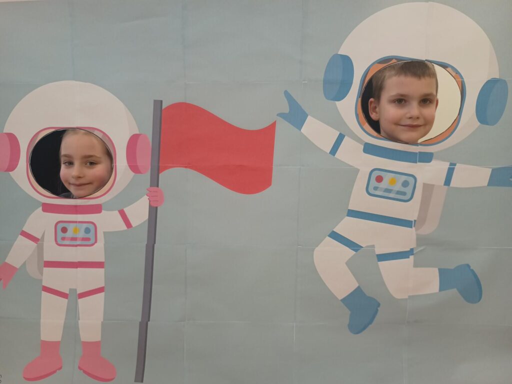 Dzieci pozują do zdjęć w strojach astronautów