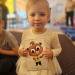 Dziewczynka z karta obrazkową- na której jest jeden z bohaterów - Tom the bear.