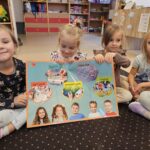 Dziewczynki prezentuja plakat ze słownictwem- zabawy i gry.