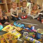 Dzieci z karmą oraz akcesoriami dla zwierząt.