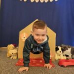 Chłopiec wychodzący z kartonowej budy.