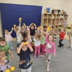 Dzieci pokazują żółtą piłeczkę.