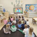 Dzieci oglądają "Królewnę Śnieżkę" na tablicy interaktywnej.