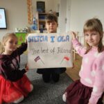 Trójka dziewczynek z plakatem. Dopingują swoją koleżankę.