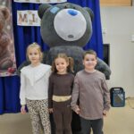 Trójka dzieci z dmuchanym misiem.