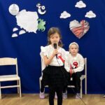 Zdjęcie ukazuje dziewczynkę wykonującą swoją piosenkę. 