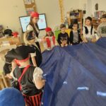 Na zdjęciu widać dzieci wraz z n-lem podczas zabawy z plandeką jako morze.