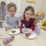 Dwie dziewczynki dekorują upieczone pierniczki.