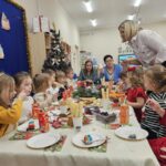 Dzieci wraz z Paniami na przy wigilijnym stole.