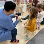 Dzieci dzielą się opłatkien z panią.