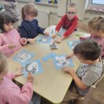 Zdjęcie ukazuje dzieci przy stoliku. Wykonują misia polarnego.