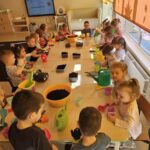 Dzieci wypełniają ziemią dobniczki.