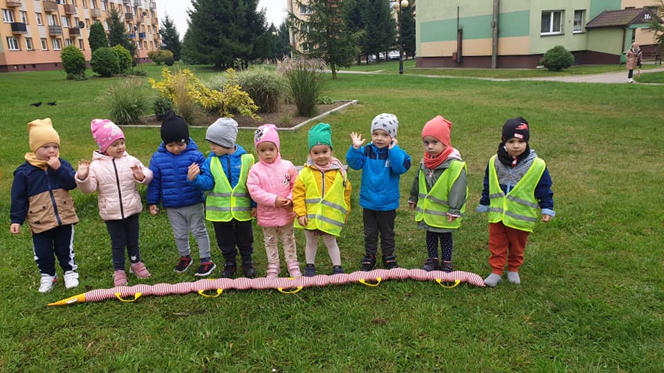 Przedszkolaki prezentują swojego "węża", który służy maluchom do nauki chodzenia w parach.