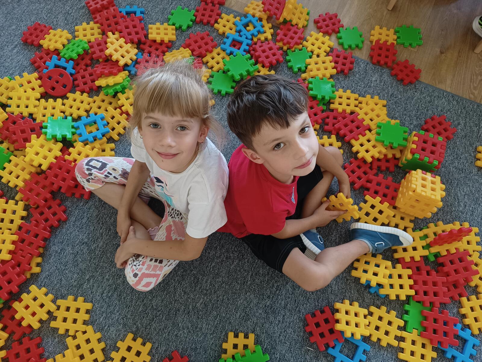 Chłopiec i dziewczynka bawią się kolorowymi klockami