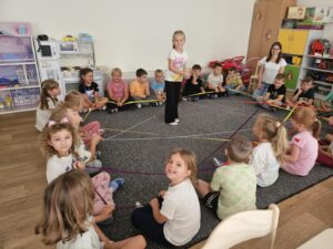 Dzieci tworzą Pajęczynę Przyjaźni z kłębka wełny.