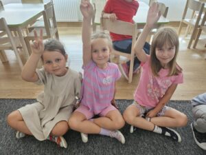 Dziewczynki ukazujące zasadę - ręka do góry, jeżeli chcesz coś powiedzieć.