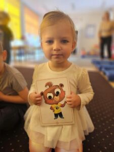 Dziewczynka z karta obrazkową- na której jest jeden z bohaterów - Tom the bear.