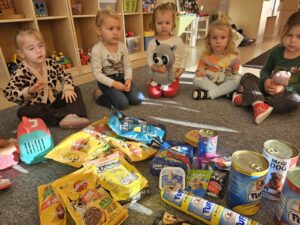 Dzieci z karmą oraz akcesoriami dla zwierząt.