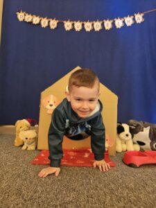 Chłopiec wychodzący z kartonowej budy.