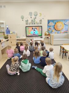 Dzieci oglądają "Królewnę Śnieżkę" na tablicy interaktywnej.