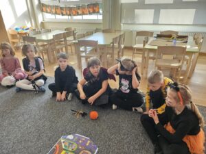 Dzieci słuchaja bacznie i powtarzają nowego słownictwa. Przyglądają sie obrazkom na plakacie.