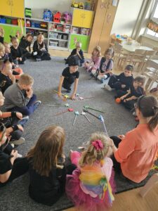 Dzieciaki utrwalają kolory przy pomocy ręcznie wykonanych różdżek.