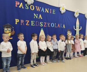 Dzieci stoją w rzędzie, przed rodzicami, prezentują i piosenki.