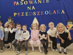 Dzieci po występie, siedzące na ławce.