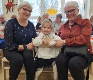 Wnuczka z babciami w trakcie poczęstunku.